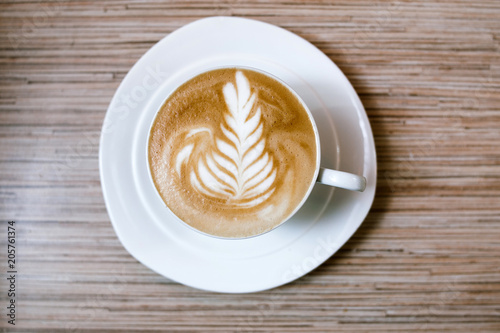 coffee and caffeine dependence. traditional morning energy beverage. cappuccino drink in a white cup on wooden background. top view of mug of latte