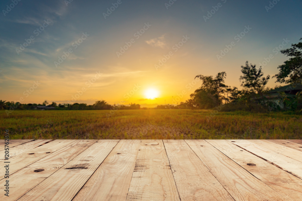 Obraz premium Pusty drewniany blat i wyświetlacz montaż z rozmycie tła pole zachód słońca.
