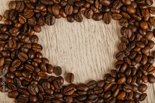 Grains of coffee on a wooden background in large quantities