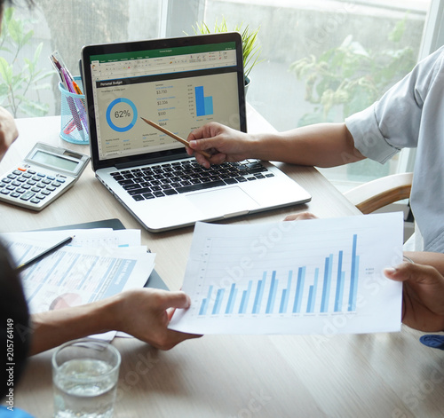 Top view hand of business team during meeting conference are working documents about the marketing plan and sales report finance of the company with laptop computer and smartphone tablet on work table