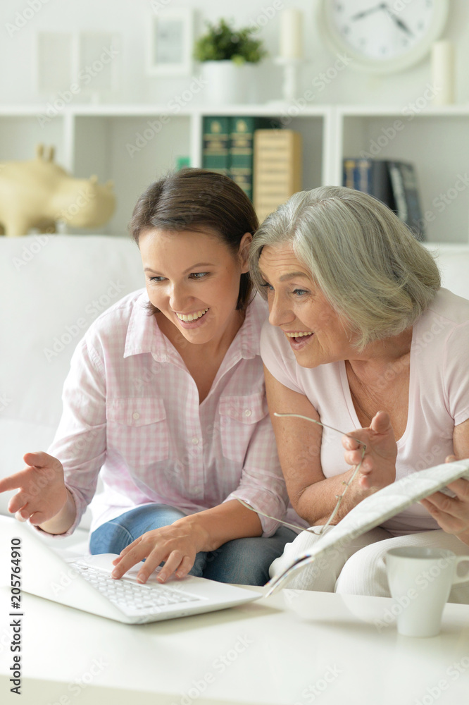 young beautiful woman with mother using laptop young beautiful woman with mother using laptop