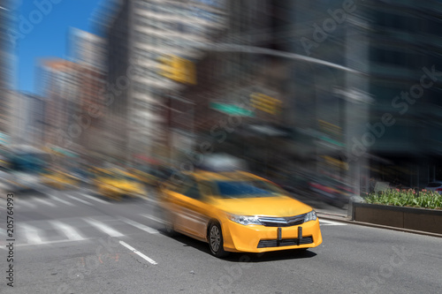 Fototapeta Naklejka Na Ścianę i Meble -  New York City yellow taxi cab speeding through the streets of Manhattan with motion blur effect