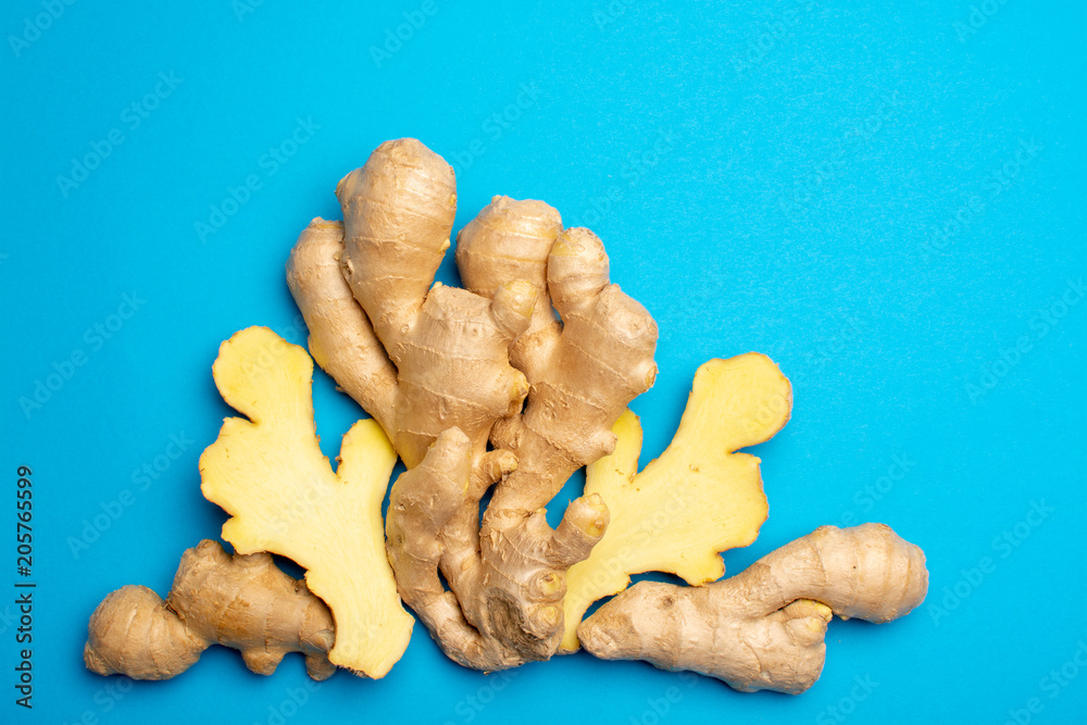 Fototapeta premium Trendy food flat lay concept on blue background with fresh big ginger root close up copy space isolated