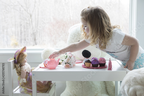 A little girl having a pretend tea party.