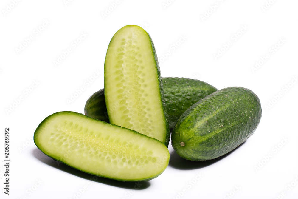 Fresh small green cucumbers whole and sliced close up copy space isolated on white background Fresh small green cucumbers whole and sliced close up copy space isolated on white background