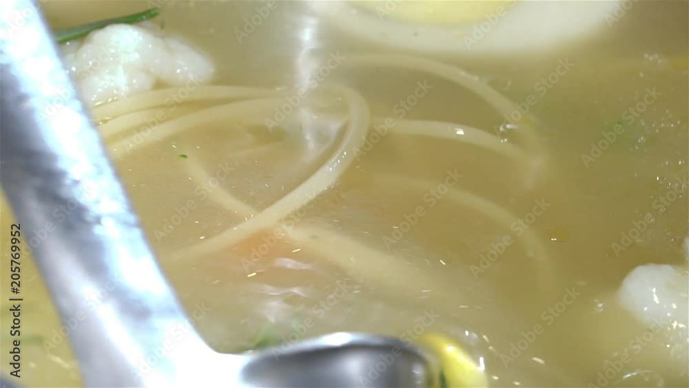 Soup ladle pour chicken soup in the plate. Broth with noodles, meatballs and broccoli Soup ladle pour chicken soup in the plate. Broth with noodles, meatballs and broccoli