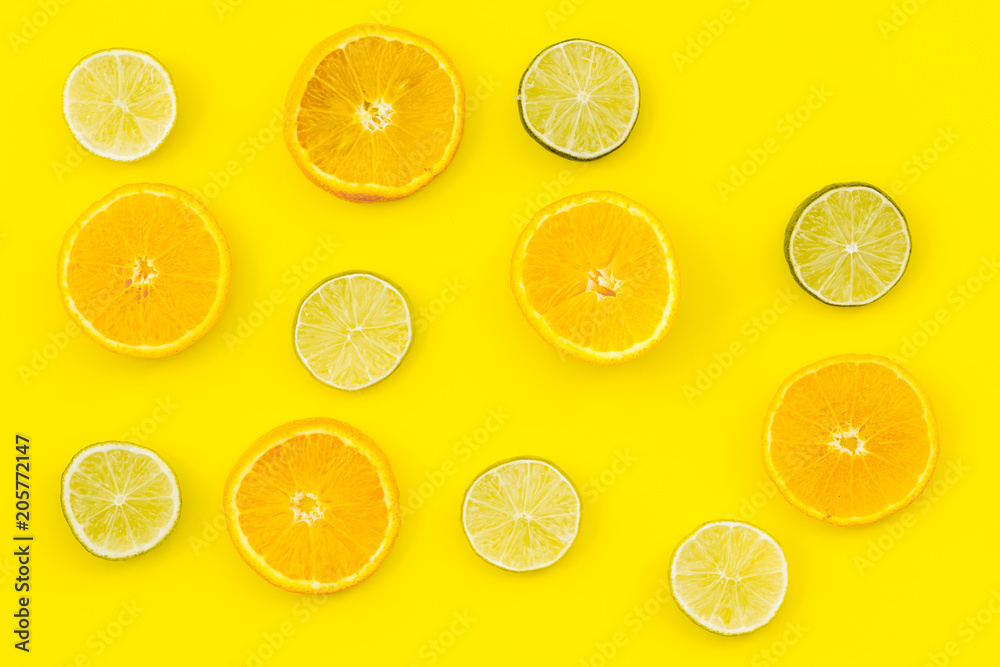 Fruit pattern. Oranges and lime round slices composition on yellow background top view