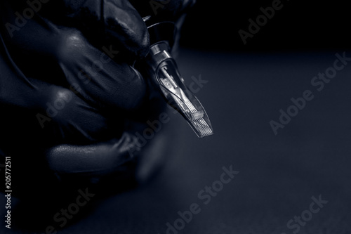 Woman master holding tattoo machine  preparing for drawing picture