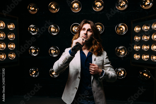 men singer with long hair, with microphone on the stage