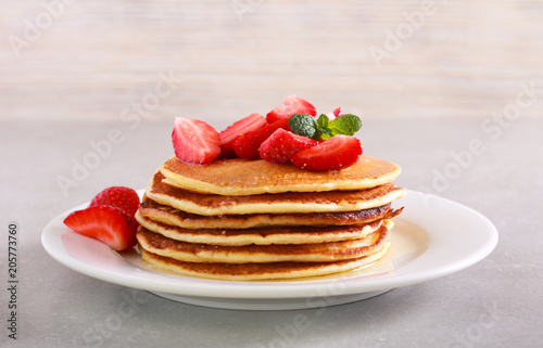 Pile of pancakes with strawberry on plate