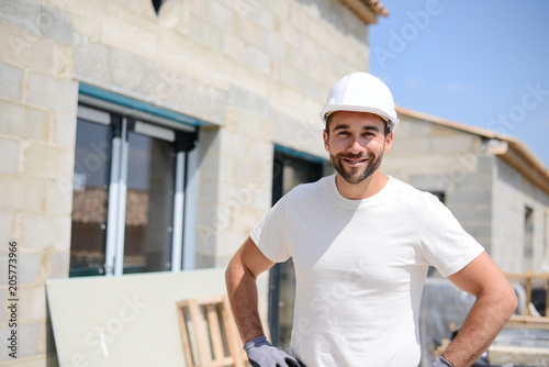 Tableau sur toile portrait of handsome construction worker on a house building industry constructi