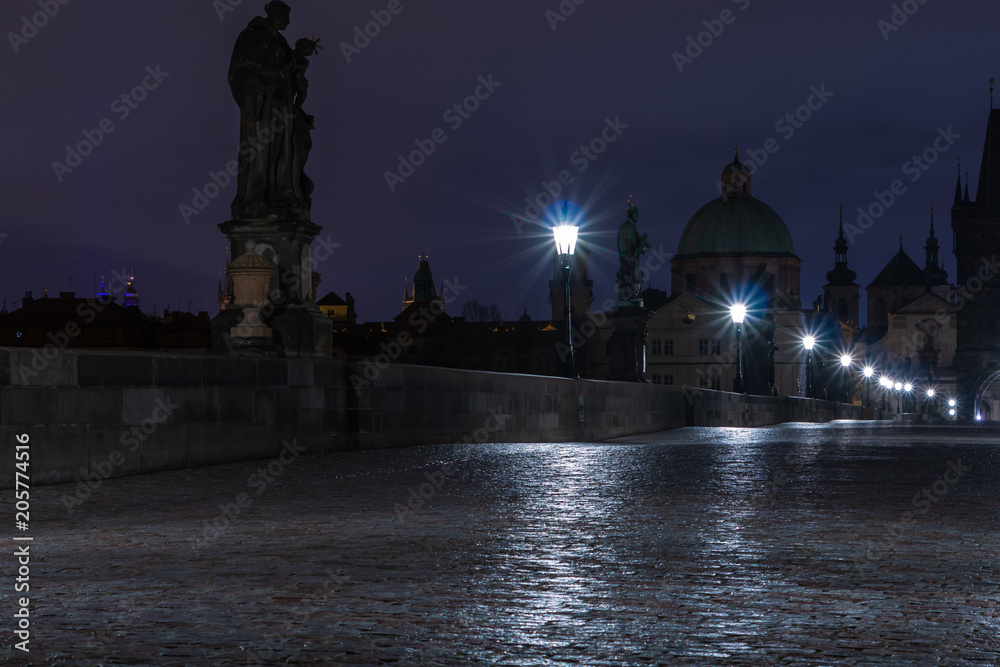 Karlsbrücke in Prag über die Moldau bei Nacht. Dämmerung mit nassem Kopfsteinpflasterboden