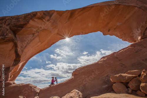Mother with her baby son stay below Skyline arch in Arches National Park in Utah, USA