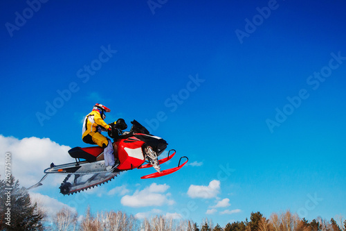Snowmobile races jump in snow. Concept winter sports.