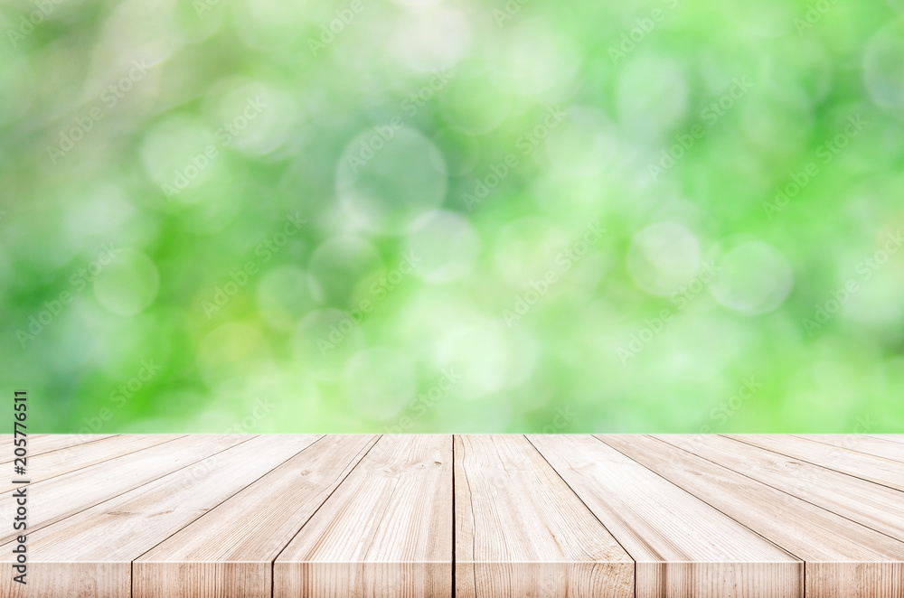 Empty wooden table top with blurred green garden background.