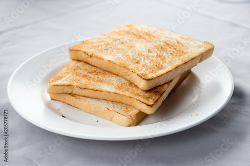 Stack of toasted bread on white dish background