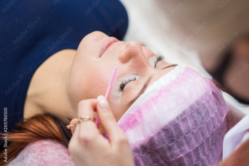Procedure for eyelash extension. The master combs the rifles with a brush Procedure for eyelash extension. The master combs the rifles with a brush