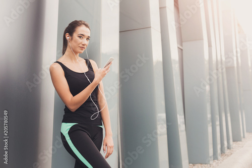 Cheerful sporty woman having rest after workout
