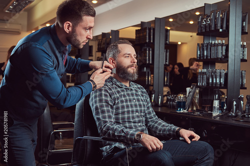 Professional barber working with a client in a hairdressing salon.