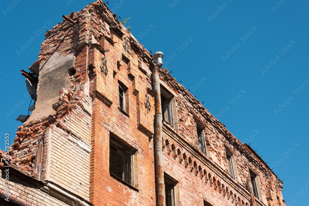 Old destroyed houses of brick with windows, wall.
