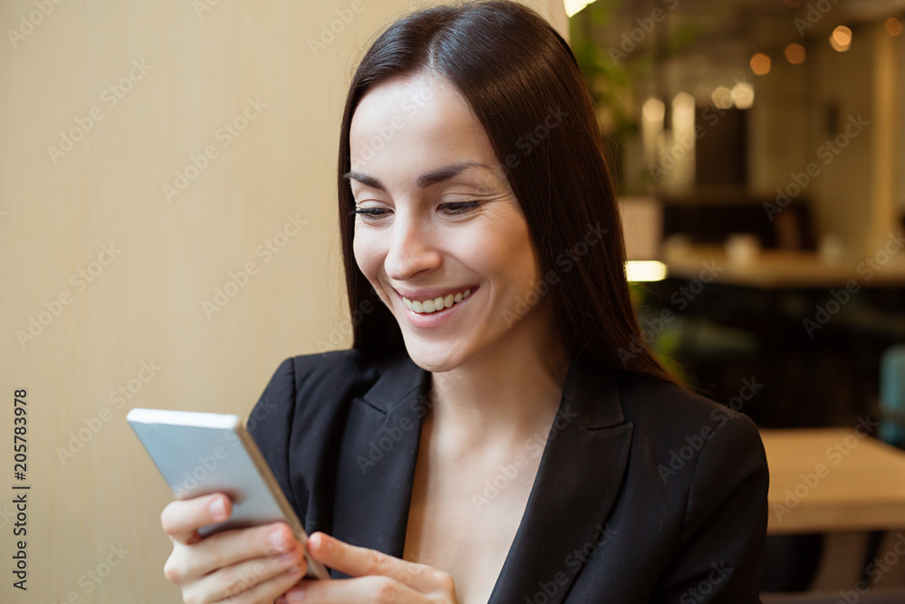 Gorgeous smiling woman texting on the phone indoors Gorgeous smiling woman texting on the phone indoors