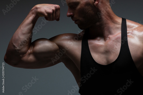 The torso of attractive male bodybuilder flexing his muscles in studio shot. Concept Gym Life Style.
