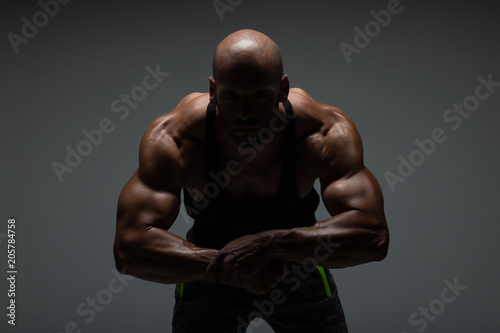 The torso of attractive male body builder flexing his muscles in studio shot. Concept Gym Life Style.