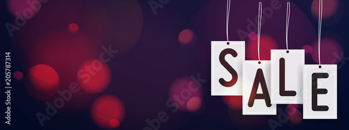 Hanging sale stickers header with blurred bokeh lights in the background. Sale hanging concept for special offer.