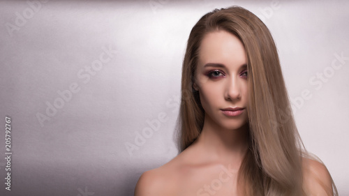 Beautiful young girl on a gray background.