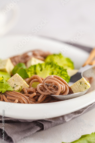 Vegetarian Soba Noodles with tofu and broccoli, white background. Healthy vegan food concept.