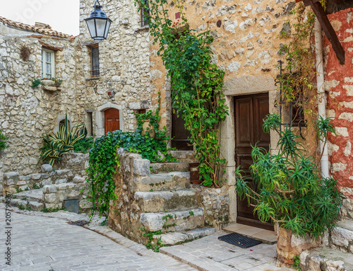 Narrow cobbled street with flowers in the old village Tourrettes-sur-Loup   France.