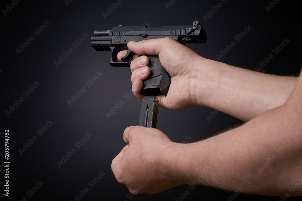 reloading a handgun, inserting ammunition clip reloading a handgun, inserting ammunition clip