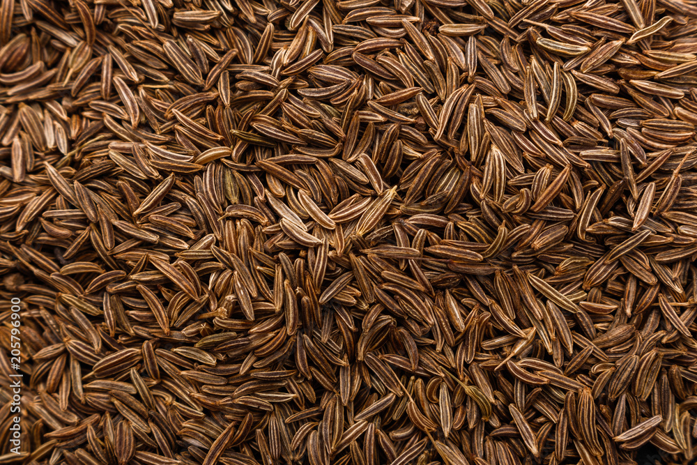 Seeds of cumin on a dark stone background