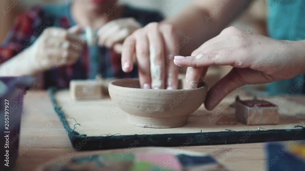occupation on manual modeling of clay. female hands close-up. girl sculpts a clay plate occupation on manual modeling of clay. female hands close-up. girl sculpts a clay plate