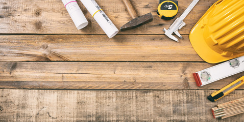 Project construction blueprints and engineering tools on wooden desk, copy space, top view