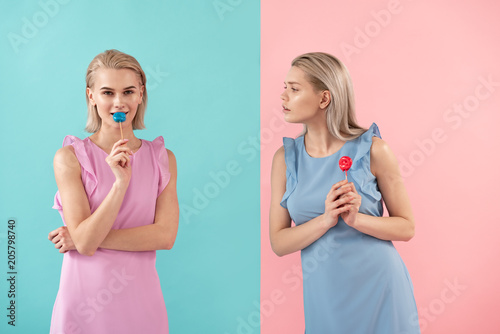 Two girls holding sweets on stick Fototapeta