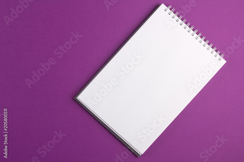 Blank notebook on purple background. Flat lay concept