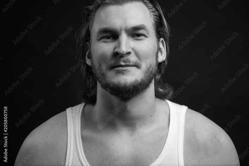 white and black shot of unshaven guy with long fair hair in singlet