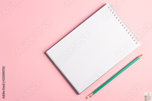 Blank notebook with pencil on pink pastel background. Flat lay concept with copy space