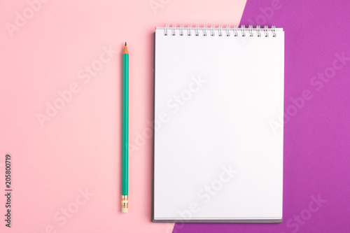 Blank notebook with pencil on pink purple pastel background. Flat lay concept with copy space