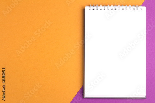 Blank notebook on purple orange pastel background with copy space. Flat lay concept
