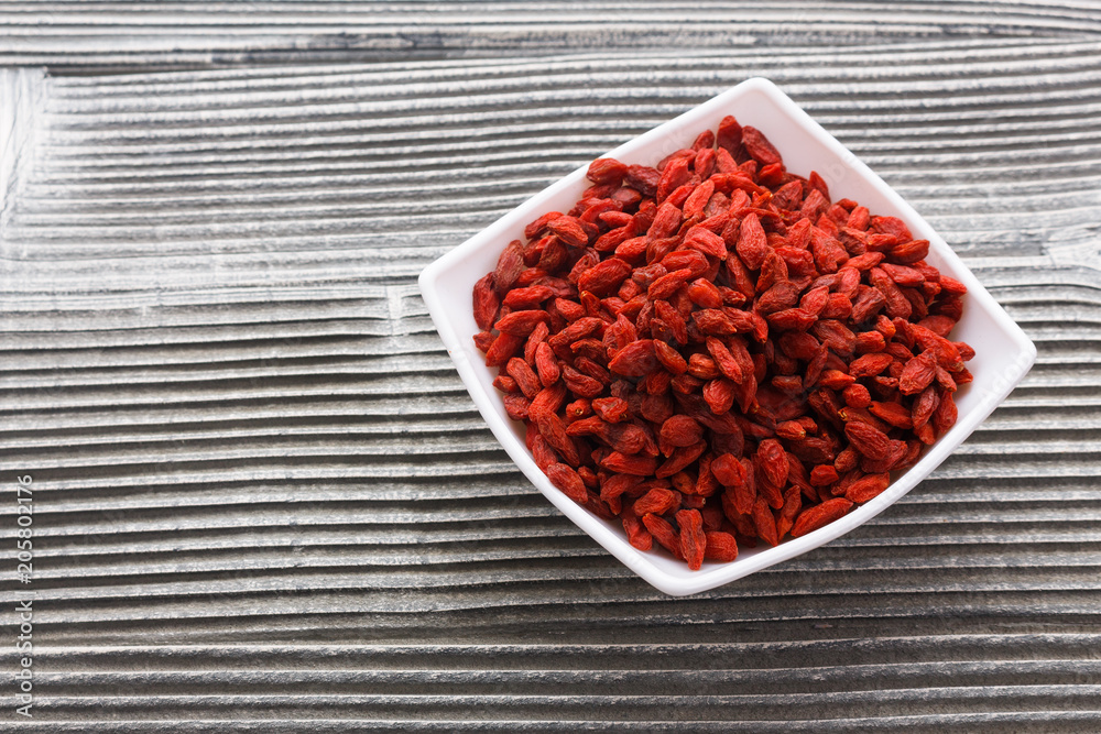 dried goji berries on a wooden rustic background dried goji berries on a wooden rustic background