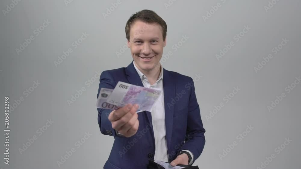 The businessman takes out money from the purse and extends it to the camera The businessman takes out money from the purse and extends it to the camera