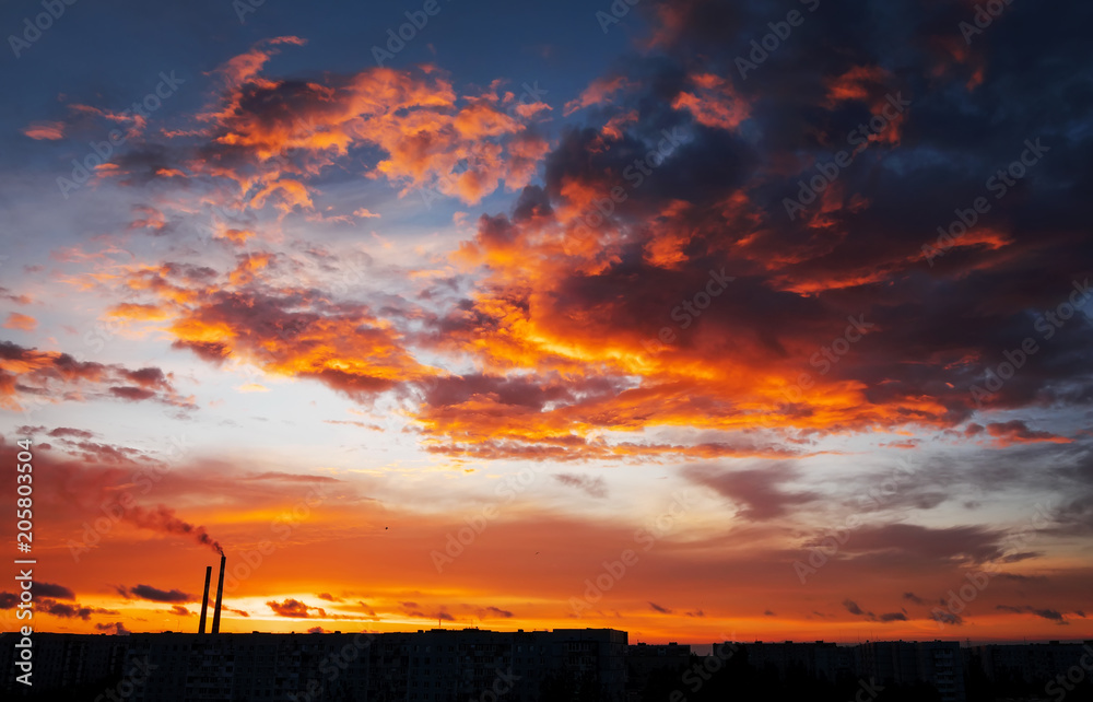 Colorful Magic Sunset. Roofs of city houses during sunrise. Birds flying in the sky. Dark smoke coming from the thermal power plant pipe. Colorful Magic Sunset. Roofs of city houses during sunrise. Birds flying in the sky. Dark smoke coming from the thermal power plant pipe.