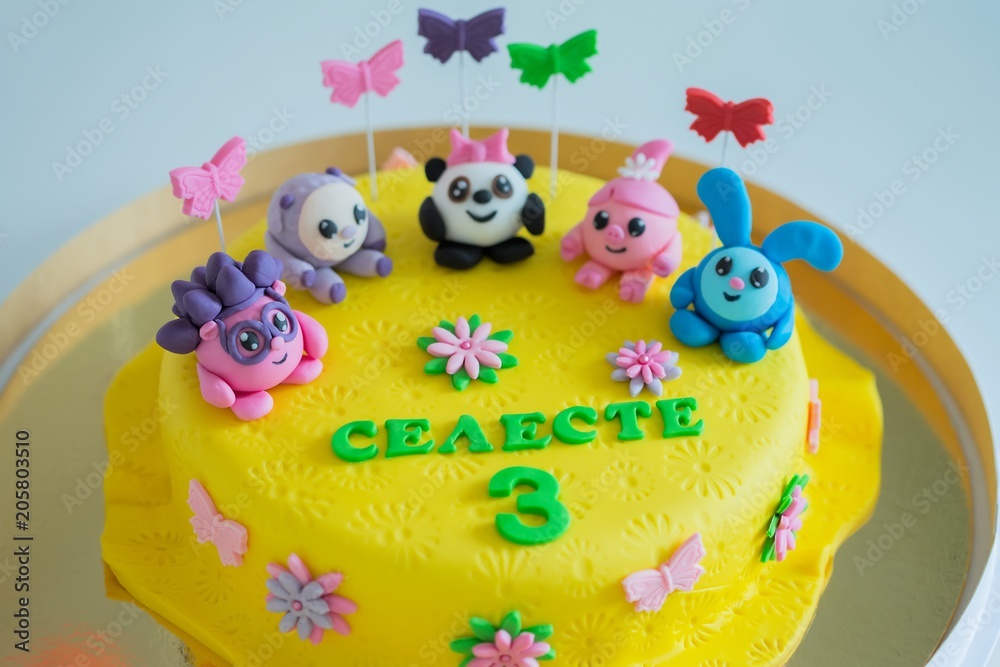 Child colorful birthday cake decorated with little cartoon characters on  the top. Stock Photo | Adobe Stock
