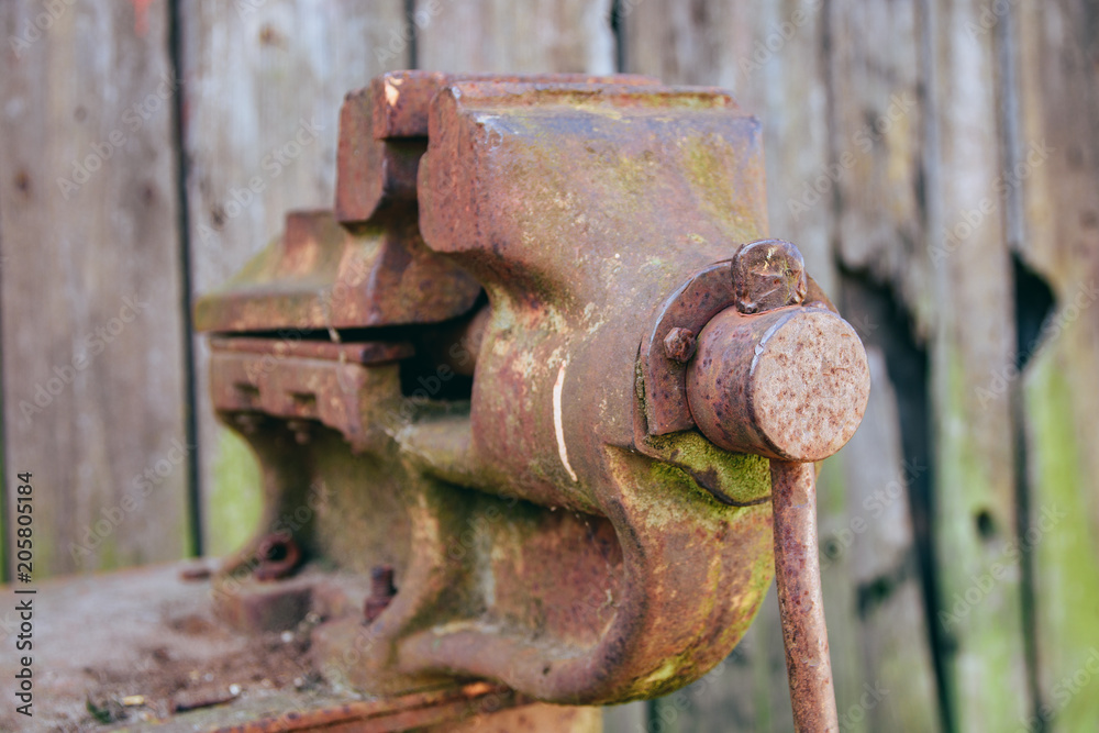 old clamp vice on a wooden background old clamp vice on a wooden background