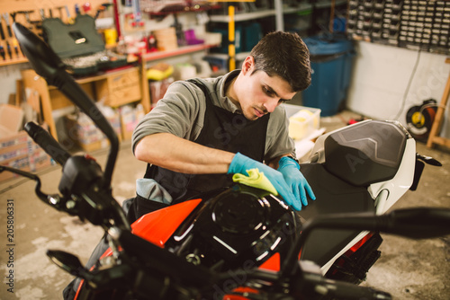 Mechanic polishing and cleaning a motorcycle