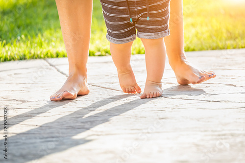 Mother and Baby Feet Taking Steps Outdoors