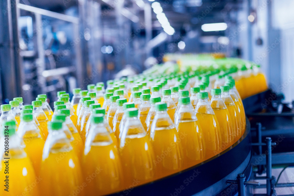 Conveyor with bottles for juice or water. Beverages factory equipments