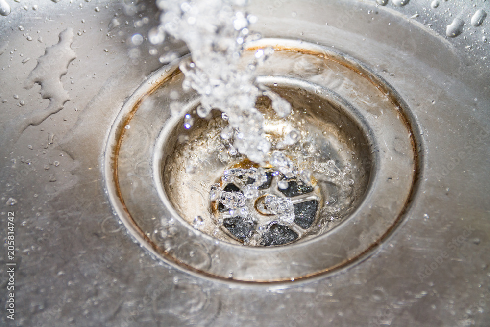 Water drains into the sink, sink and running water for the background, takes care of the water Water drains into the sink, sink and running water for the background, takes care of the water